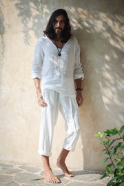 A model wearing the Kian Linen Shirt and matching drawstring pants in a crisp white tone, embodying effortless bohemian elegance. This lightweight, breathable outfit is made from natural fabrics, perfect for slow fashion enthusiasts. From Bird of Paradise, Bali boho clothings
